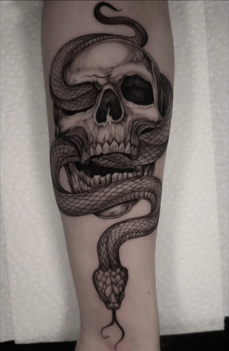 Skull and snake blackwork tattoo